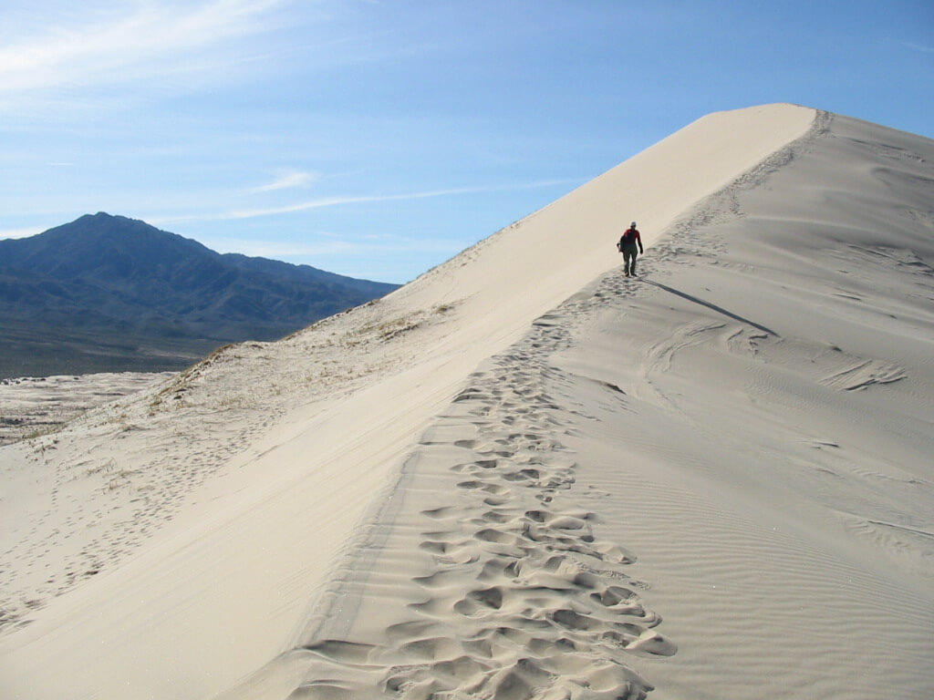 Hiking at Kelso Dunes / Wikipedia / Binksternet https://en.wikipedia.org/wiki/Kelso_Dunes#/media/File:Hiking_Kelso_Dunes_ridge.jpg
